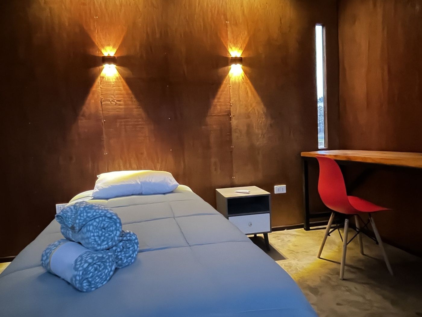 Dormitorio con camas individuales y luz cálida sobre madera
